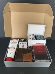 an open box containing several items including a passport, notebooks and other personal care products