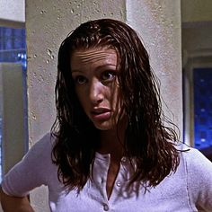 a woman with wet hair standing in front of a window