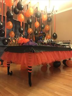 an orange and black party table with balloons