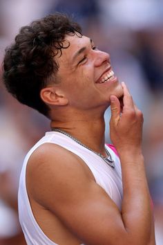 a tennis player is smiling and holding his hand to his face