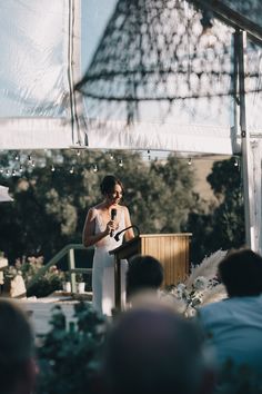 a woman standing at a podium in front of an audience