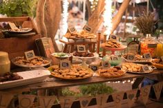 a table filled with lots of food on top of wooden tables covered in bunting