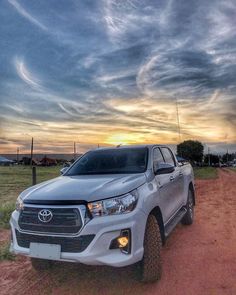 a silver truck parked on top of a dirt road