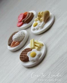 four miniature plates with food on them sitting on a table