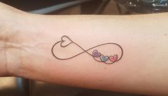 a tattoo on the arm of a woman with two hearts in an infinite love knot