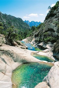 a river running through a rocky valley surrounded by mountains