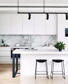 an instagram page with white cabinets and black bar stools in the kitchen area