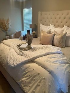 a large bed with white sheets and pillows