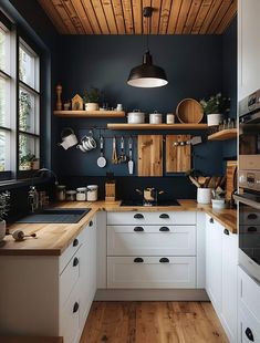 a kitchen with wooden floors and white cabinets, black walls and wood paneling on the ceiling