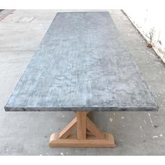 a table that is made out of concrete and wood with a wooden base on the top