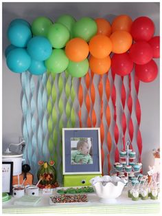 a baby's first birthday party with balloons and streamers