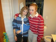 two young women standing next to each other in a room with a toilet and shower