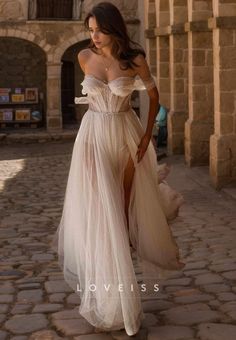 a woman in a white dress is walking down the street