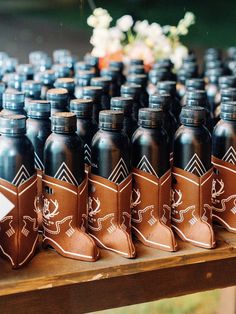 many black bottles are lined up on a table