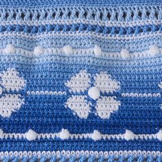 a crocheted blue and white blanket with flowers on it's edges, made to look like snowflakes