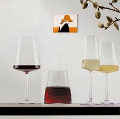 three wine glasses filled with different types of wine sitting on a table next to each other