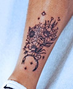 a woman's arm with flowers on it and stars in the sky behind her