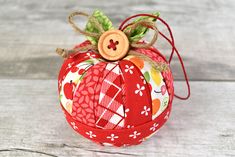 an ornament made out of fabric with a wooden button on the top, sitting on a table