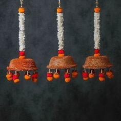 three orange and white bells hanging from strings