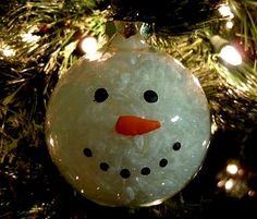 a snowman ornament hanging from a christmas tree