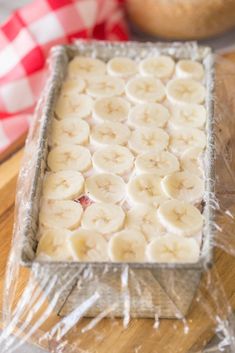 a pan filled with banana slices on top of a wooden table