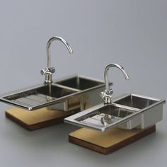 two metal sinks sitting on top of each other