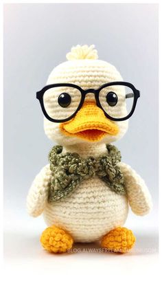 a crocheted duck wearing glasses and a bow tie