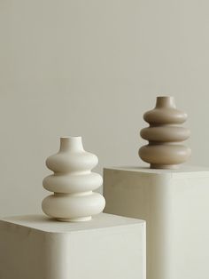 two white vases sitting on top of each other