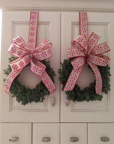 two wreaths with red and white bows on them