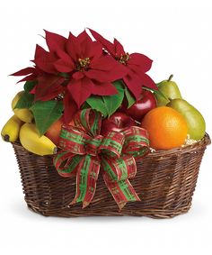 a basket filled with fruit and poinsettis