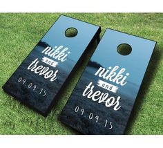 two black and white cornhole game boards on grass