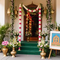 a luxurious and elaborate floral arrangement, possibly part of a wedding or a ceremonial event. The setup includes hanging floral chandeliers, large flower sculptures resembling lotus flowers, and intricately designed floral arches. The backdrop includes lush greenery, and the setting appears to be outdoors or in a large open space with a high ceiling. The overall ambiance is elegant and opulent, with a strong emphasis on floral decor. Traditional Backdrop Decoration, Traditional Backdrop, Floral Chandeliers, Ganesh Decoration, Simple Backdrop, Floral Arches, Main Doors, Pooja Decor