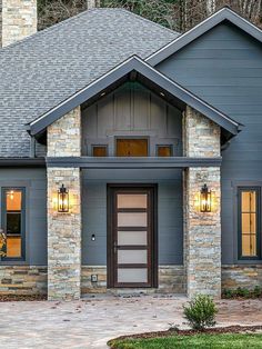 a gray house with two lights on the front door