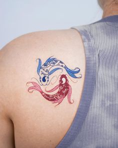 a woman with a tattoo on her shoulder has a blue and red fish in it