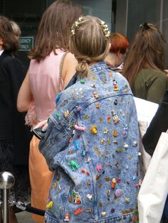 a woman wearing a jean jacket with lots of studs on it