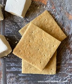 crackers and marshmallows sitting on a table next to some sugar cubes