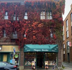 an old building covered in vines and ivys on the side of it's street