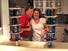 a man and woman standing next to each other with cans stacked on top of them