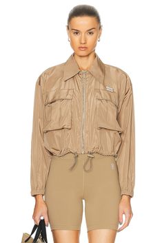 Find MIU MIU Cropped Jacket In Tan on Editorialist. Miu Miu Cropped Jacket in Tan 76% recycled polyester 24% silk. Made in Italy. Dry clean only. Front zipper closure. Elastic drawcord hem. Breast flap pockets with velcro closures. Elastic cuffs Embossed Miu Miu logo at breast. Ripstop fabric with perforated back. MIUF-WO25. ML913 121G. About the designer: Established in 1992 by Miuccia Prada, Miu Miu reflects fashion forward, light-hearted, and provocative women. The language of Miu Miu experiments with contemporary femininity, merging rebelliousness with minimalism in order to evoke a sense of freedom within luxury fashion. As a member of the Prada family, Miu Miu is made for those who aspire to add a flair of the avant-garde to their lifestyle. Khaki Nylon Outerwear For Work, Miu Miu Spring Outerwear For Work, Spring Miu Miu Outerwear For Work, Miu Miu Spring Workwear Outerwear, Fall Khaki Nylon Utility Jacket, Nylon Utility Jacket For Workwear, Miu Miu Fall Outerwear, Miu Miu Outerwear For Fall, Khaki Nylon Track Jacket With Pockets