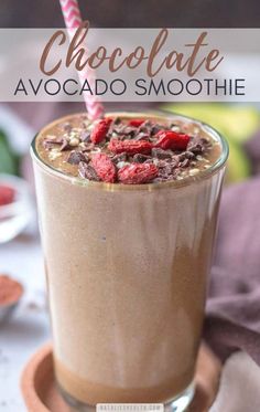 chocolate avocado smoothie in a tall glass with a pink and white straw