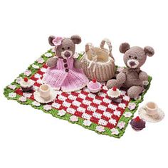 two teddy bears sitting on a picnic blanket with tea cups and saucers in front of them