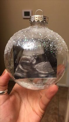 someone is holding up a glass ornament with an image on the top and bottom