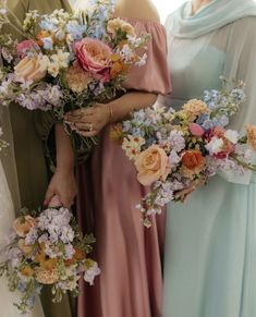 three bridesmaids holding bouquets of flowers in their hands