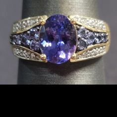 R265. $389 Size7. 1.43ct Oval Tanzanite With .93ctw Round Blue Tanzanite And .23ctw Round White Diamond 10k Yellow Gold Ring. 3.0grams. Measures Approximately 3/8"L X 1/16"W. Never Worn. Est Retail Value: $944.00. Made In Thailand. Anniversary Tanzanite Sapphire Ring With Gemstone Accents, Tanzanite Gemstones With Gemstone Accents For Anniversary, Tanzanite Rings With Gemstone Accents For Anniversary, Classic Tanzanite Multi-stone Jewelry, Classic Tanzanite Gemstones For Anniversary, Tanzanite Gemstones For Anniversary, Tanzanite And Diamond Ring, Tanzanite Diamond Ring, Blue Tanzanite