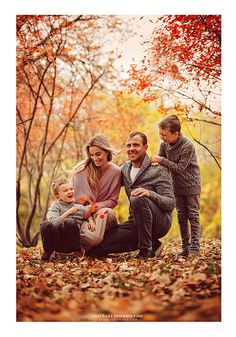 a family posing for a photo in the fall leaves