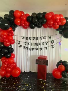 an arch made out of black and red balloons