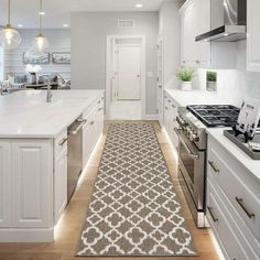 a kitchen with white cabinets and an area rug on the floor that matches the countertop