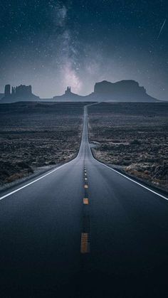 an empty road in the middle of nowhere at night with stars and milky above it