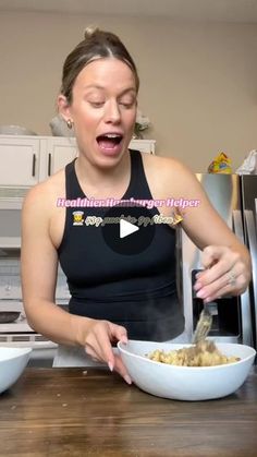 a woman in a black tank top is making a face while mixing food into a bowl