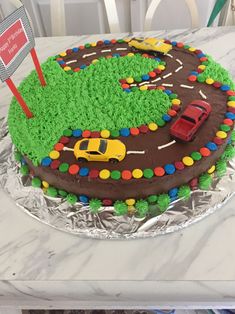 a birthday cake decorated with cars and roads